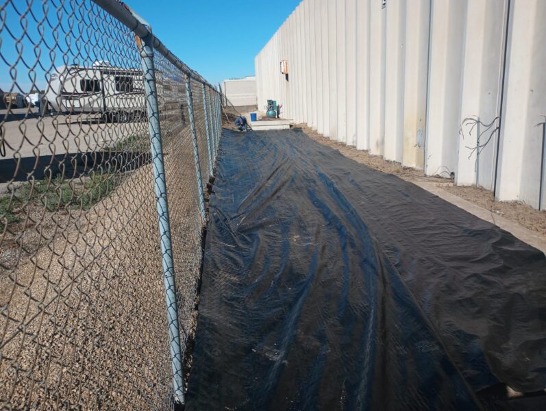 Weed barrier next to fence